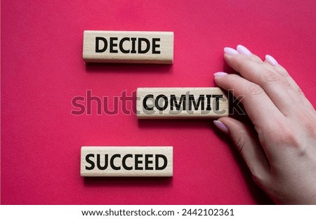 Decide Commit Succeed symbol. Concept words Decide Commit Succeed on wooden blocks. Businessman hand. Beautiful red background. Business concept. Copy space.
