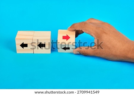 A decision contrast cubes concept featuring a hand selecting a divergent direction to illustrate alternative thinking and strategic differentiation.
