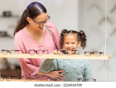 Decision, glasses and girl with her mother at the optometrist for vision and check on eyes together. Customer, medical and child shopping for eyeglasses with her mom at the ophthalmologist clinic