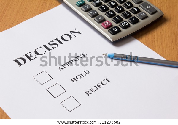 Decision paper (approve, hold, reject) with\
pen, calculator