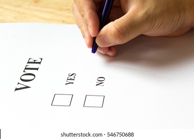 Decision paper with yes and no choice with man hold the pen on wood background