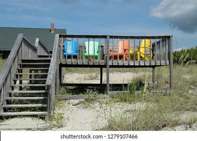 Deck at the beach with colorful array of Adirondack chairs for relaxing oceanfront.
