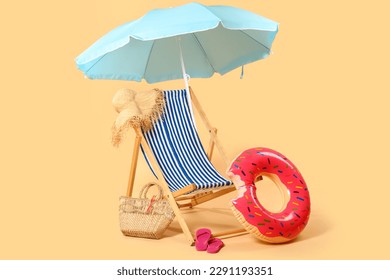 Deck chair, blue umbrella and beach accessories on beige background - Powered by Shutterstock