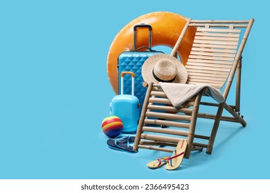 Deck chair, suitcases and beach accessories on light blue background, space for text. Summer vacation - Powered by Shutterstock