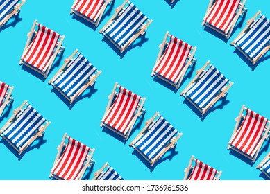 Deck chairs pattern on blue paper background. Flat lay and copy space. Summer travel vacation concept. Creative design, minimal flat lay concept. Minimal composition. Summer time