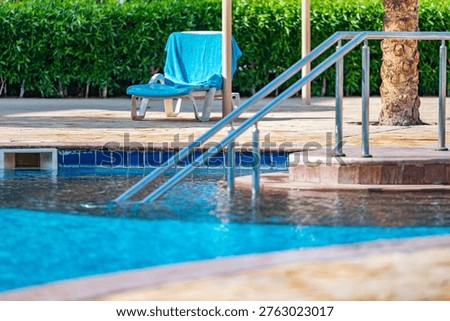 deck chairs under a canopy stand near the swimming pool