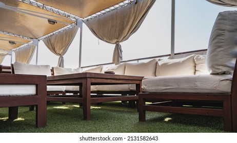 The Deck Of The Cruise Ship Is Covered With A Carpet Of Artificial Grass. There Is A Soft Sofa, Armchairs, A Wooden Coffee Table. There Is An Awning On Top. The Curtains Are Tied Up. Egypt