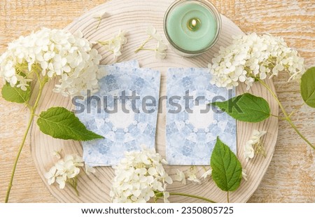Deck with homemade divination Angel cards on wood table with hydrangea flower for decoration. Home indoors candle burning.