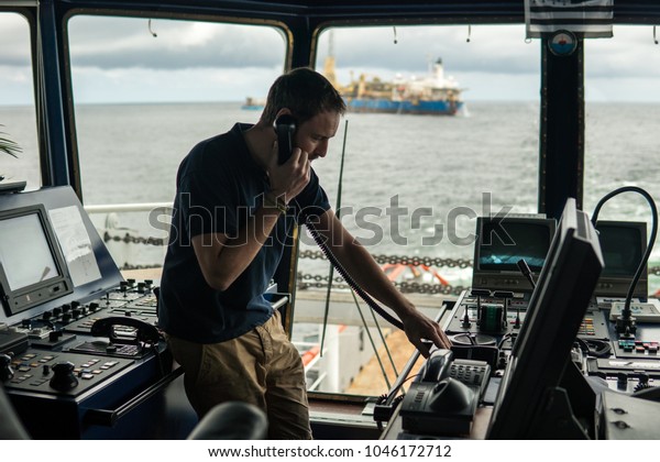 Deck navigation officer on the navigation bridge.\
He speaks by VHF radio, GMDSS Watchkeeping, collision prevention at\
sea. COLREG