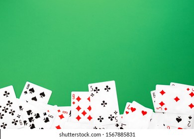 Deck of playing cards on green background table copy space