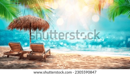 Deckchairs With Parasol With Leaves Palm In Tropical Beach With Sunny Sand And Ocean - Abstract Defocused Seascape And Glittering Effects