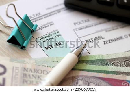 Declaration of the amount of earned income or incurred loss, PIT-36 and PIT-36L tax forms on accountant table with pen and polish zloty money bills close up