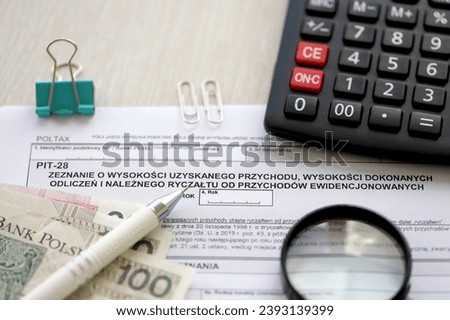 Declaration of amount of income obtained, amount of deductions made and lump sum due from recorded income, PIT-28 form on accountant table with pen and polish zloty money bills close up