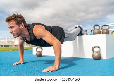 Decline Push Up Fitness Man Doing Strength Training Exercise Pushup At Outdoor Gym With Feet Elevated.