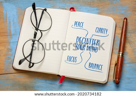 Declutter your mind for clarity, peace, focus and balance - handwriting in a notebook or journal with acup of tea, minimalism, self care and personal development concept.