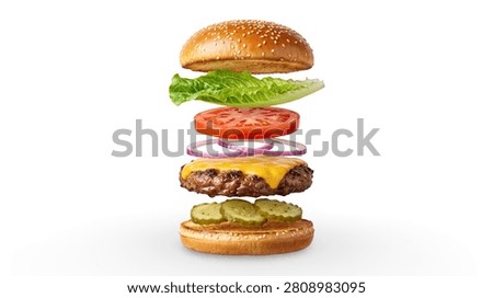 Deconstructed Floating Cheeseburger with Exploded Layers of Sesame Bun, Lettuce, Tomato, Red Onion, Cheese, Beef Patty, and Pickles Isolated on White Background