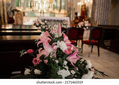 A Decor Of Flowers In The Catholic Church And Wooden Benches