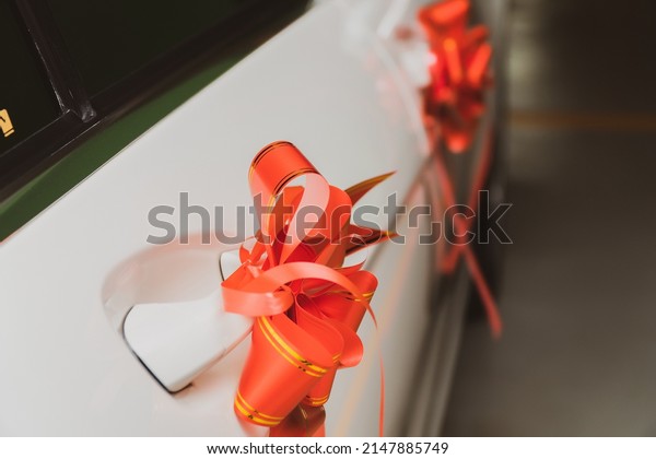 Decorate the wedding limousine, tie the car\
ribbons, car front\
dolls