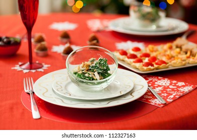 Decorated Christmas dining table with delicious salad (spinach, pear, blue cheese and pine tree nuts)