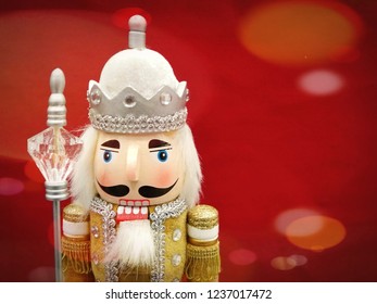 A decorated Christmas Nutcracker against a red background and lots of star light twinkle effect. Perfect for Christmas card. Lots of space for text.