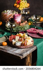 Decorated Christmas Table Served For 3 Persons. Cheese Plate With Grape, Ham, Candle, Cake.