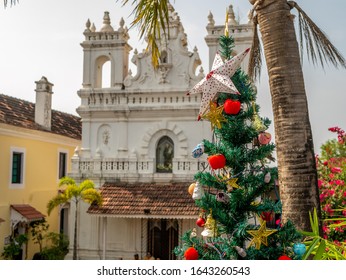 A Decorated Christmas Tree In Backdrop Of Beautiful Church In Goa