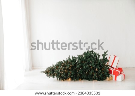 Decorated Christmas tree fallen down. Christmas gifts near fallen tree. Christmas tree.