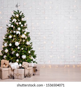 Decorated Christmas Tree, Heap Of Gift Boxes And Copy Space Over White Brick Wall Background