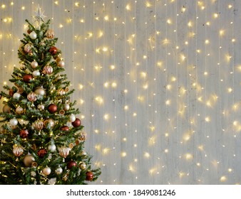 Decorated Christmas Tree Over Grey Wall With Led Lights