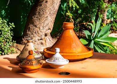 Decorated, earthenware pots on a table in a garden.