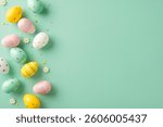 Decorated Easter eggs arranged on a green background with small flowers and empty area