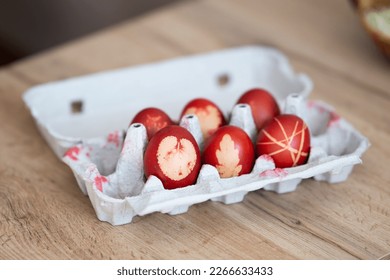Decorated easter eggs in egg box. Red easter eggs in egg carton.  Easter eggs decorated with leaves. Interesting method for decorating easter eggs.