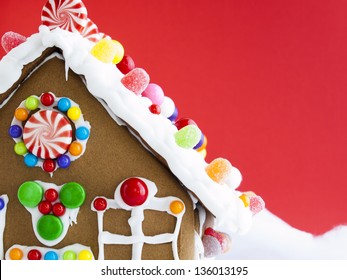 Decorated Gingerbread House On Red Background.