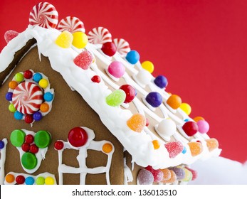 Decorated Gingerbread House On Red Background.