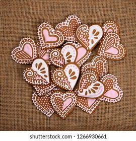 Decorated heart shape gingerbread cookies on burlap canvas background