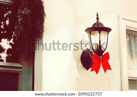 Decorated lamp light with red ribbon on the wall in christmas day.