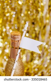 Decorated Mini Champagne Bottle On Bright Sparkling Blurred Background