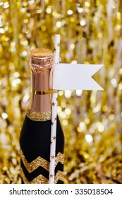 Decorated Mini Champagne Bottle On Bright Sparkling Blurred Background