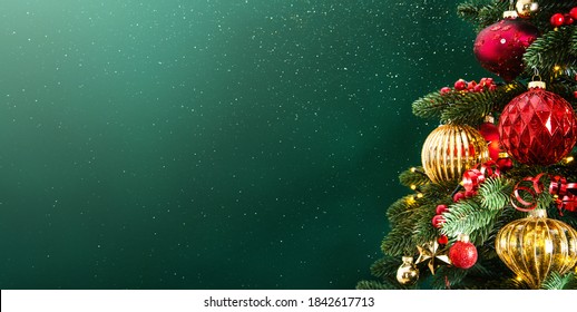 Decorated with ornaments and lights Christmas tree on dark green background. Merry Christmas and Happy Holidays greeting card, frame, banner. New Year. Noel. Winter holiday theme. 