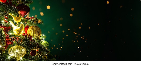 Decorated with ornaments and lights Christmas tree on dark green background. Merry Christmas and Happy Holidays greeting card, frame, banner. New Year. Noel. Winter holiday theme. 
				