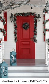 Decorated Red Door For Christmas Holidays With Blue Lanterns On The Stairs