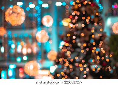Decorated shopping mall Christmas eve festive time unfocused abstraction concept with bokeh lights on Christmas tree and walls, vibrant bright colors 