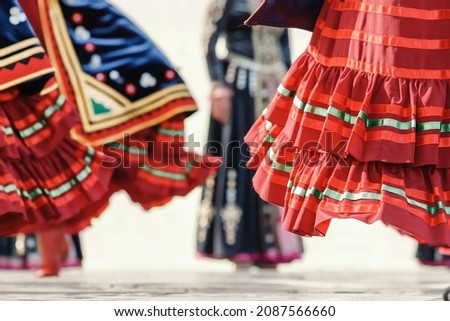 Decorated traditional Bashkir skirt flutters in folds during the dance with spinning red boots in the foreground