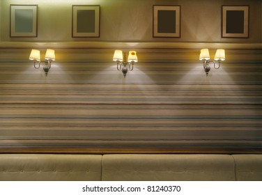 Decorated wall in a cafe, empty frames on the wall, vintage lamps, leather seats and wallpapers.