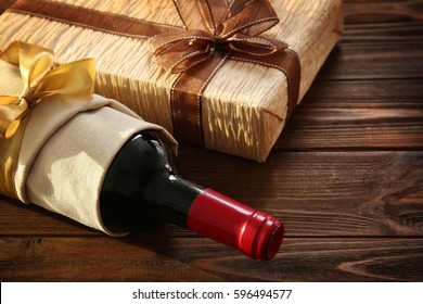 Decorated Wine Bottle And Gift Box On Wooden Background