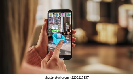 Decorating Apartment: Woman Holding Smartphone, using Augmented Reality Interior Design Software Chooses 3D Furniture for Home. Pick a Stylish Chair for the Living Room. Over Shoulder Close-up Screen - Powered by Shutterstock