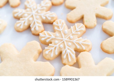 Decorating Christmas Sugar Cookies With Royal Icing And Sprinkles.