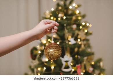 Decorating Christmas tree, holding Christmas toy in a hand. Holiday, Christmas and New Year family celebration concept - Powered by Shutterstock