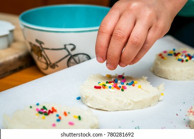 Decorating Cookie Dough With Sprinkles By Kid Hand.