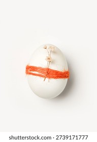Decorating for Easter with eggs wrapped in thread and adorned with small flowers shows a creative approach to holiday traditions. Simple designs highlight festive spirit.